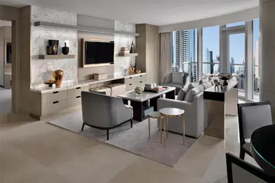 a living room with a television and a table and chairs at Kempinski Central Avenue Dubai in Dubai