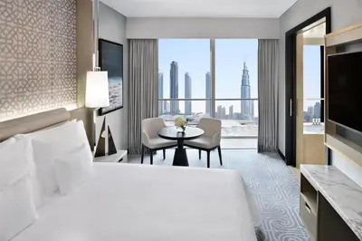 a hotel room with a bed and a table with chairs at Kempinski Central Avenue Dubai in Dubai