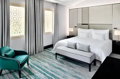 a hotel room with a bed and a chair at Address Montgomerie in Dubai