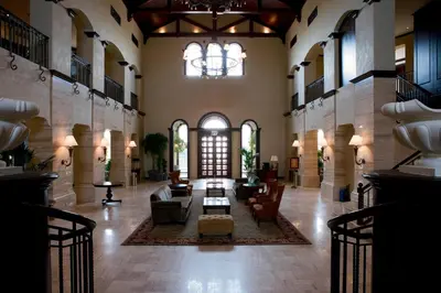 a large lobby with a couch and chairs and a chandelier at Arabian Ranches Golf Club in Dubai