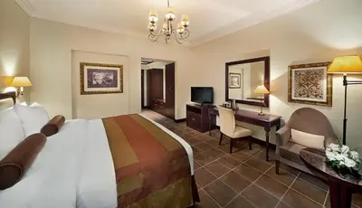 a hotel room with a large bed and a desk at Arabian Ranches Golf Club in Dubai