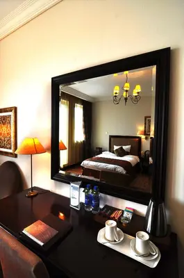 a bedroom with a bed and a desk with a mirror at Arabian Ranches Golf Club in Dubai