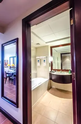 a bathroom with a tub and a large mirror at Arabian Ranches Golf Club in Dubai