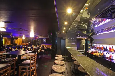 a restaurant with a bar with tables and stools at Sea View Hotel Dubai in Dubai