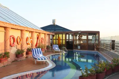 a swimming pool with two chairs and a building at Sea View Hotel Dubai in Dubai