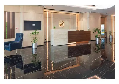 a lobby with a reception desk and a blue chair at Wescott Plaza Hotel Apartments LLC Formerly West Zone Plaza Hotel Apts in Dubai