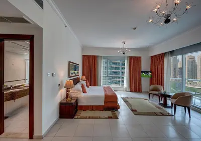 a hotel room with a bed and a large window at Marina Hotel Apartments in Dubai