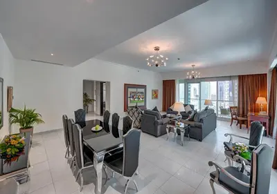 a living room with a table and a dining room at Marina Hotel Apartments in Dubai