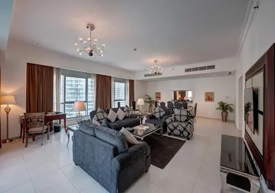 a large living room with couches and a television at Marina Hotel Apartments in Dubai