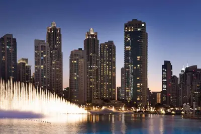 a water fountain in front of a city at night at Ramada by Wyndham Downtown Dubai in Dubai
