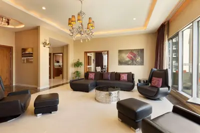 a living room with black furniture and a chandelier at Ramada by Wyndham Downtown Dubai in Dubai