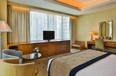 a hotel room with a bed and a desk and a television at Social Hotel in Dubai