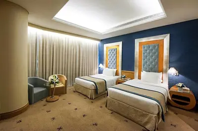 a hotel room with two beds and a chair at Social Hotel in Dubai