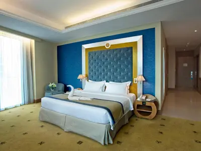 a bedroom with a large bed with a blue wall at Social Hotel in Dubai