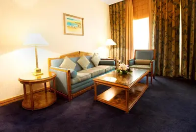 a living room with a couch and a table at Capitol Hotel Jumeirah Dubai in Dubai