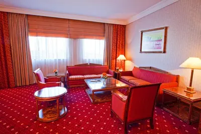 a hotel room with a couch and a table at Capitol Hotel Jumeirah Dubai in Dubai