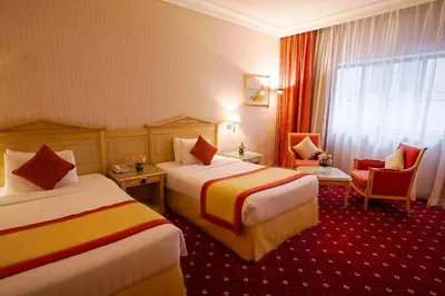 a hotel room with two beds and a window at Capitol Hotel Jumeirah Dubai in Dubai