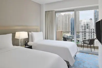a hotel room with two beds and a large window at JW Marriott Hotel Marina in Dubai