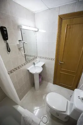 a bathroom with a toilet and a sink and a door at Welcome Hotel Apartments 1 in Dubai