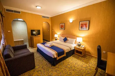 a hotel room with a bed and a chair at Welcome Hotel Apartments 1 in Dubai