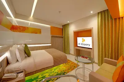 a bedroom with a bed and a table and a couch at Al Khoory Atrium in Dubai