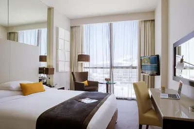 a hotel room with a bed and a desk at Centro Barsha - by Rotana in Dubai