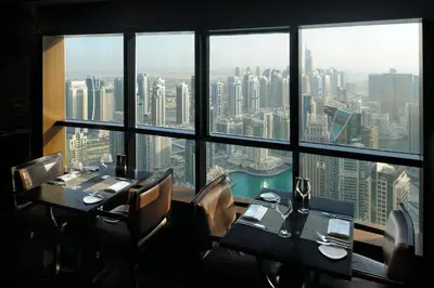 a restaurant with two tables and a view of the city at Dubai Marriott Harbour Hotel And Suites in Dubai