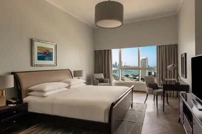 a bedroom with a bed and a large window at Dubai Marriott Harbour Hotel And Suites in Dubai