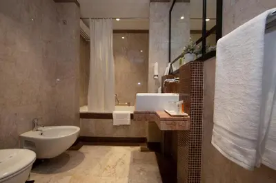 a bathroom with a sink and a toilet and a tub at Number One Tower Suites in Dubai