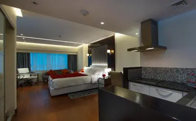 a bedroom with a bed and a kitchen with a desk at Number One Tower Suites in Dubai