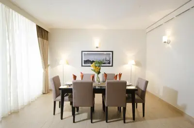 a dining room with a table and chairs at The Apartments, Dubai World Trade Centre in Dubai