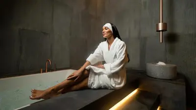 a woman sitting in a bath tub in a bathroom at Aspen Chalets by Kempinski Hotel Mall of The Emirates in Dubai