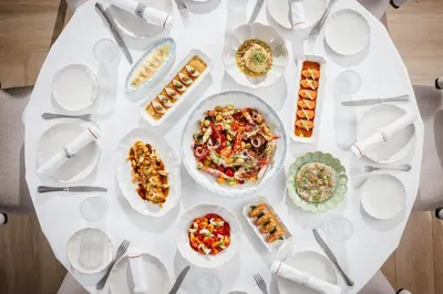 a white table with plates of food on it at Aspen Chalets by Kempinski Hotel Mall of The Emirates in Dubai