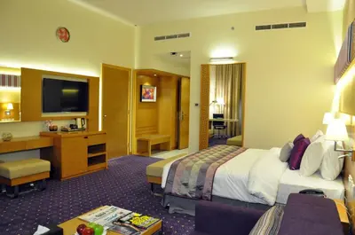 a hotel room with a bed and a desk at Fortune Park Hotel in Dubai