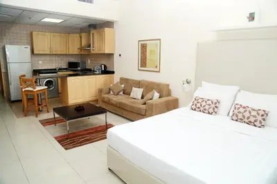 a bedroom with a bed and a living room with a kitchen at Armada Living - Holiday Homes Rental in Dubai