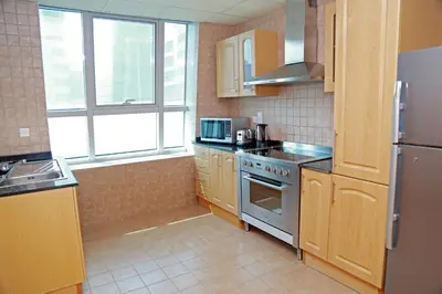 a kitchen with a stove and a refrigerator at Armada Living - Holiday Homes Rental in Dubai