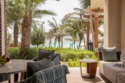 a patio with chairs and a table and palm trees at Jumeirah Al Naseem Dubai in Dubai