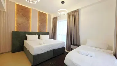 a hotel room with two beds and a window at Elan Rimal Suites in Dubai