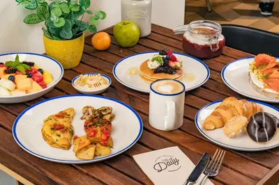 a wooden table topped with plates of breakfast foods at Rove Bur Dubai - Healthcare City in Dubai