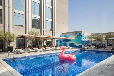 a swimming pool with a pink swan in the water at Rove Bur Dubai - Healthcare City in Dubai