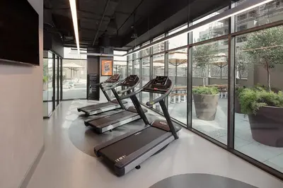 a row of treadmills in a gym with windows at Rove Bur Dubai - Healthcare City in Dubai