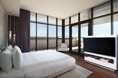 a bedroom with a large white bed and a flat screen tv at La Ville Hotel & Suites CITY WALK Dubai, Autograph Collection in Dubai