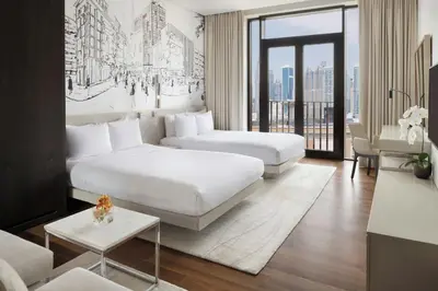 a hotel room with two beds and a couch at La Ville Hotel & Suites CITY WALK Dubai, Autograph Collection in Dubai