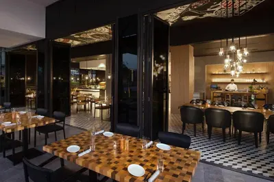 a restaurant with tables and chairs and a bar at La Ville Hotel & Suites CITY WALK Dubai, Autograph Collection in Dubai