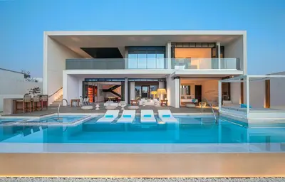 a house with a swimming pool in front of it at Nikki Beach Resort & Spa Dubai in Dubai