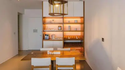 a dining room with a wooden table and white chairs at Nikki Beach Resort & Spa Dubai in Dubai