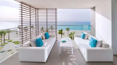 a balcony with two white couches and the ocean at Nikki Beach Resort & Spa Dubai in Dubai