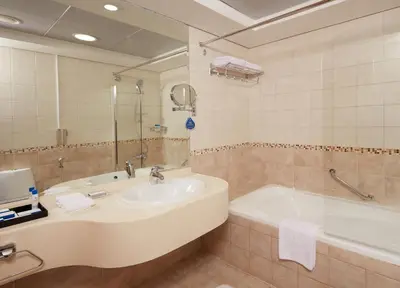 a bathroom with a sink and a bath tub at Roda Beach Resort in Dubai
