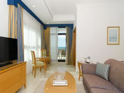 a living room with a couch and a tv and a table at Roda Beach Resort in Dubai