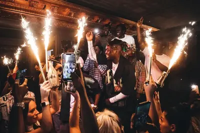 a group of people holding sparklers in a crowd at FIVE Palm Jumeirah Dubai in Dubai